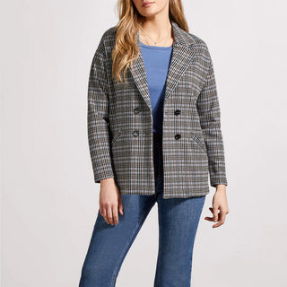A woman wearing a double-breasted plaid blazer with a notch collar, in a blue and beige check pattern, paired with a blue top and jeans.