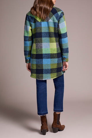 Person wearing a plaid coat with a neutral background