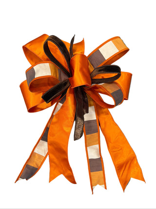 Vibrant Orange Color Block Bow
A large decorative gift bow made from bright orange ribbon with brown and white striped sections ivory cream Fall Autumn Halloween