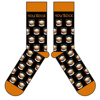 A pair of black socks with the text 'YOU ROCK' and a pattern of bourbon glasses repeated across the surface, with orange at the heel and toe.