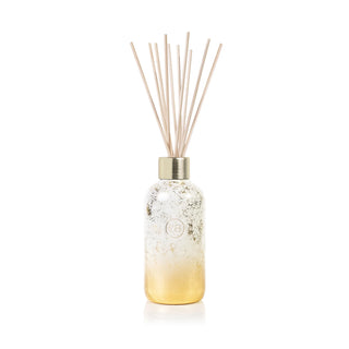 Capri Blue Volcano Glimmer Reed Diffuser bottle with wooden sticks on a white background