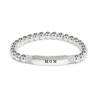 A silver-colored Brighton Meridian Mom petite stretch bracelet with the word 'MOM' engraved on one of the beads. Brighton