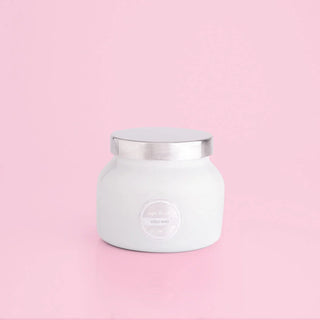 A white volcano-style jar with a metallic lid on a pink background, with a label that reads 'VOLCANO'. Capri Blue White Volcano Petite Jar