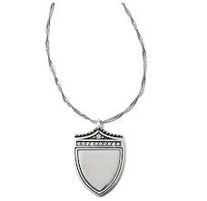 A silver necklace pendant in the shape of a shield with a high polished finish, featuring an engraved design with the word 'Love'. Brighton Medaille Shield Necklace