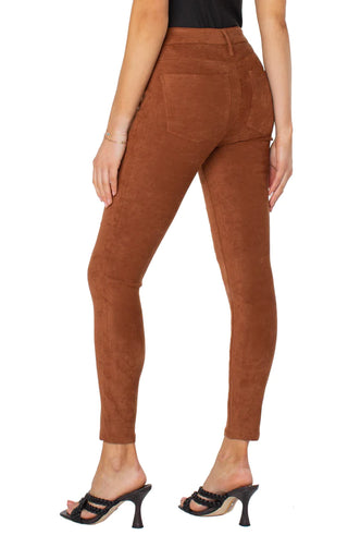 A model wearing Liverpool skinny, suede pants in a chestnut color.