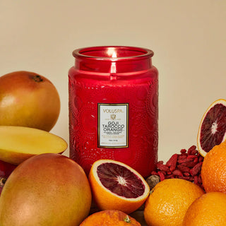 Voluspa Goji Tarocco Orange Large 18oz Jar Candle styled with blood oranges in the background