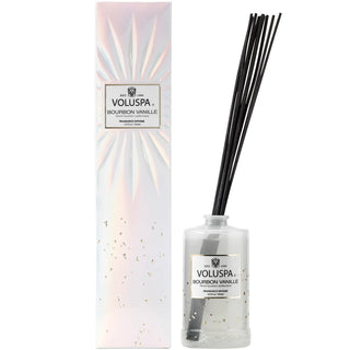 A Voluspa diffuser set with a clear bottle, black sticks, and a white box with the brand and product name. Voluspa Bourbon Vanille Diffuser